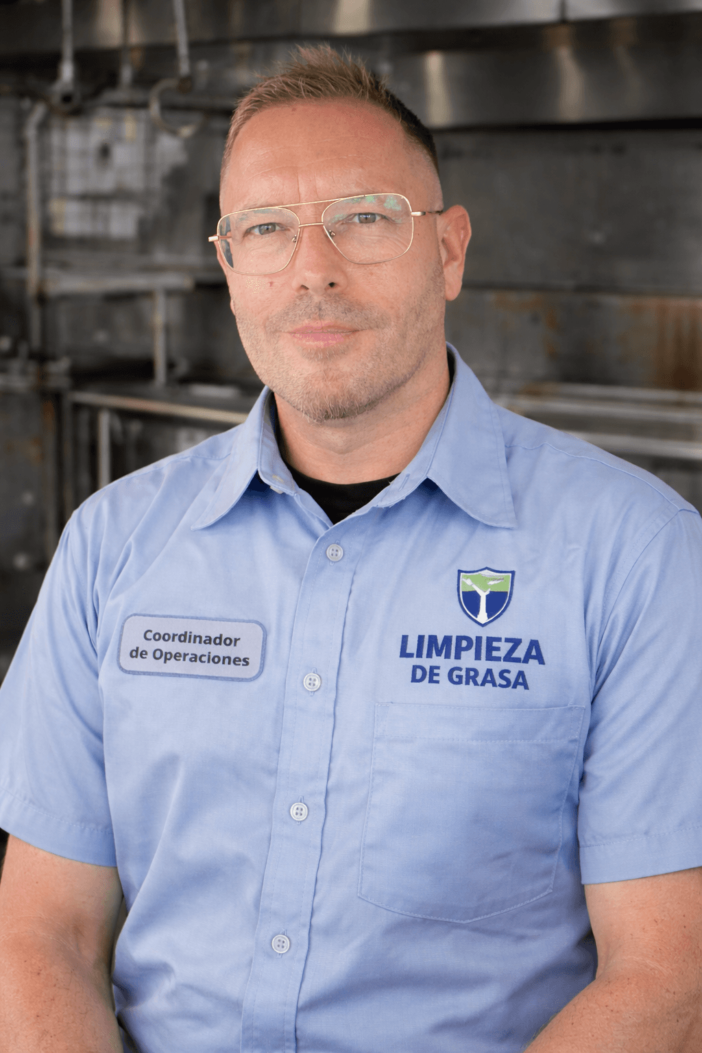 Coordinador de operaciones con gafas y camisa azul de la empresa Limpieza de Grasa.